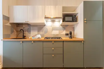 a kitchen with white cabinets and a sink and a refrigerator at YCH-Ambra Apartments a San Giovanni in Rome