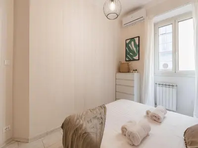 a white bedroom with a bed and a window at The Best Rent - Spacious one-bedroom apartment near Colosseum in Rome