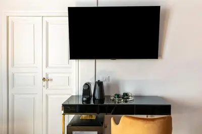 a television hanging above a desk with a chair at Residenza Il Vicolo by Hili in Rome