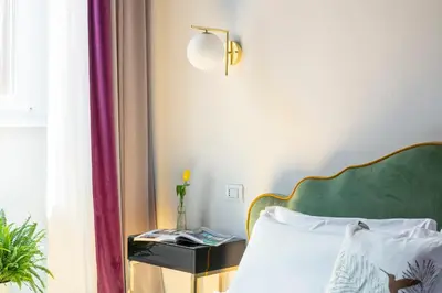 a bed with a green headboard next to a window at Residenza Il Vicolo by Hili in Rome