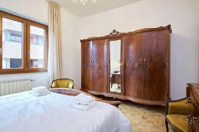 a bedroom with a wooden cabinet and a bed at Monteverde - Vaticano - Esperienza Romana 1BDR by Hôtea in Rome