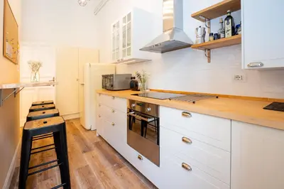 a kitchen with white cabinets and a stove top oven at Quirino Visconti Apartment Prati in Rome