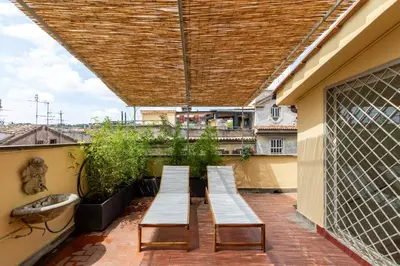 a patio with three benches on a roof at iFlat Trastevere Stylish 4 Bedroom Penthouse in Rome