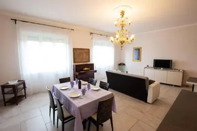 a living room with a table with chairs and a chandelier at Ninkasi Bed and Beer San Giovanni Via La Spezia 74 Roma in Rome
