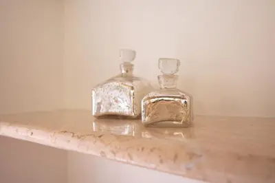 two glass bottles sitting on top of a wooden shelf at Domus Laurina - Maison D'Art Collection in Rome