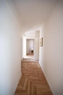 an empty hallway with white walls and wood floors at Domus Laurina - Maison D'Art Collection in Rome