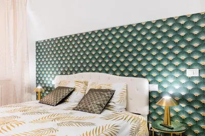 a bed with two pillows and a green wall at Colosseum Boutique apartment in Rome
