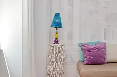 a lamp sitting next to a couch with a purple pillow at Charme e Style: Splendid Apartment with 2 Bedrooms in Rome