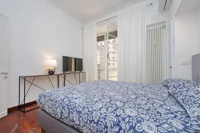 a bedroom with a bed and a television and a window at Charme e Style: Splendid Apartment with 2 Bedrooms in Rome