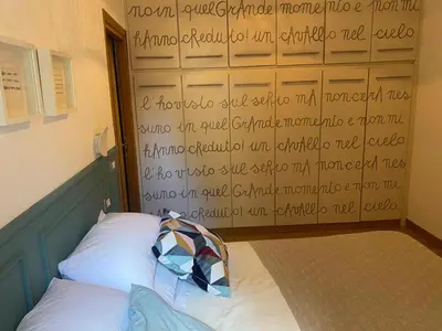 a bedroom with a wall with writing on it at Fanfulla Bilocale Pigneto in Rome