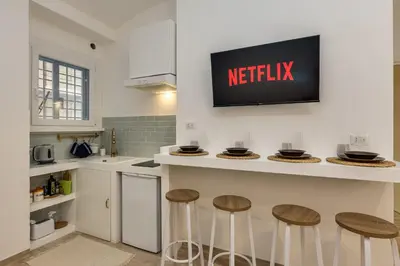 a kitchen with stools at a counter with anetflix sign on the wall at Cozy Apartment Monteverde near Trastevere in Rome