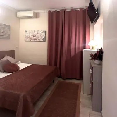 a small bedroom with a bed and a television in it at Ariana Apartments in Rome
