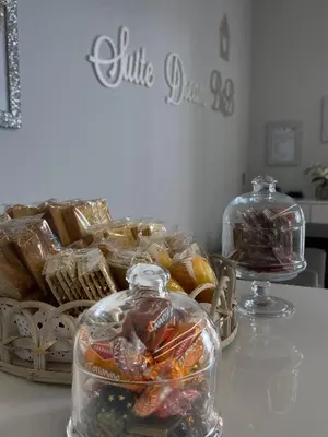 a table with a basket of pastries and jars of candy at Alissa Suite in Rome