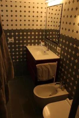 a bathroom with a sink and a toilet and a mirror at Caesars penthouse in Rome