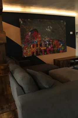 a living room with a couch and a painting on the wall at Caesars penthouse in Rome