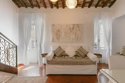 a bedroom with a large bed in a room with windows at Piazza Navona Historic Luxury Apartment in Rome