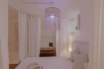 a bedroom with a white bed and a chandelier at Piazza Navona Historic Luxury Apartment in Rome