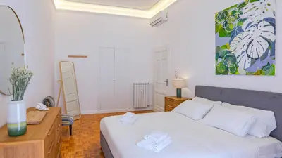 a bedroom with a bed and a desk and a painting at Domus San Giovanni Elegant Apartment in Rome