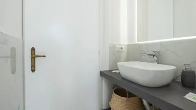 a bathroom with a white sink on a counter at Domus San Giovanni Elegant Apartment in Rome