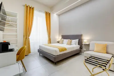 a hotel room with a bed and a chair at SCIPIONI 40 GUESTHOUSE in Rome