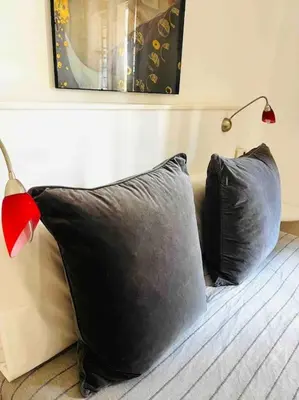 two black pillows sitting on a bed with a lamp at Trastevere Moro apartment in Rome
