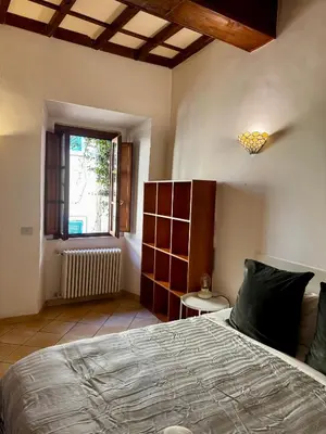 a bedroom with a large bed and a window at Trastevere Moro apartment in Rome