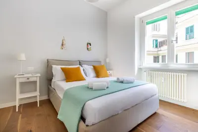 a bedroom with a large bed with orange and green pillows at Apartment near the Vatican Cipro metro station in Rome