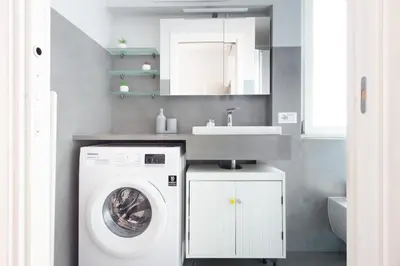 a bathroom with a washing machine and a sink at Apartment near the Vatican Cipro metro station in Rome