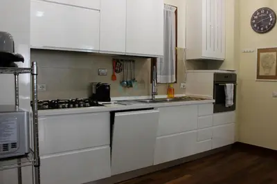 a kitchen with white cabinets and a stove top oven at Your Perfect Roman Getaway in Vatican in Rome