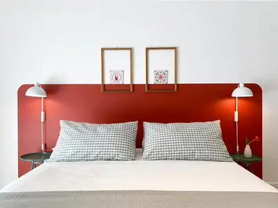 a bed with a red headboard with three pictures on it at Be Close - Porta Portese Appartamento con terrazza in Rome