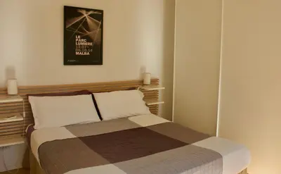 a bedroom with a bed with a poster on the wall at Quadrilatero Flat in Rome