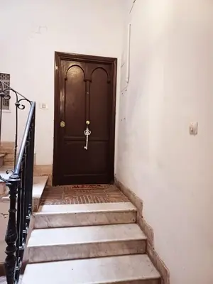 a black door with a key on a staircase at Il barone di Trastevere in Rome