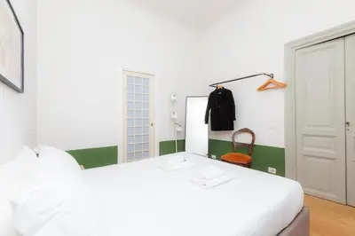 a bedroom with a white bed and a mirror at Piazza Cavour Zen Garden-ZEN36 in Rome