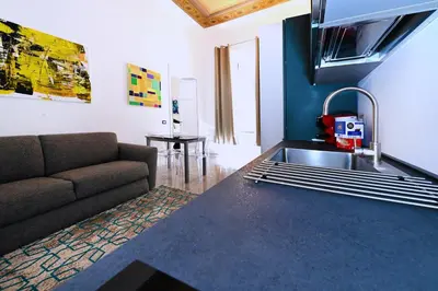 a kitchen with a couch and a sink in a room at Vatican Suites in Cola Di Rienzo in Rome