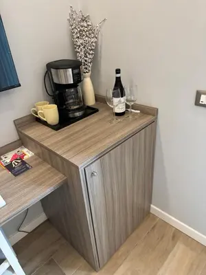 a wooden cabinet with wine glasses and a coffee maker at Niky House Roma in Rome