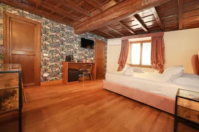 a bedroom with a bed and a desk in a room at Golden Pantheon Rooms in Rome