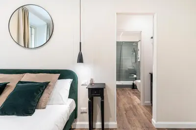 a bedroom with a green couch and a mirror at Gracchi boutique rooms in Rome