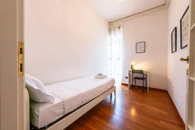 a small bedroom with a bed and a desk at Re di Roma Lodge in Rome