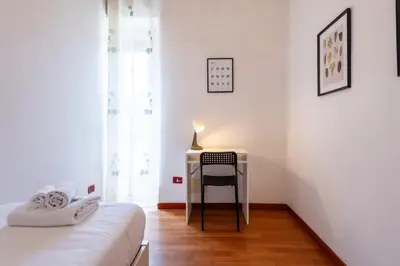 a bedroom with a desk with a chair and a bed at Re di Roma Lodge in Rome
