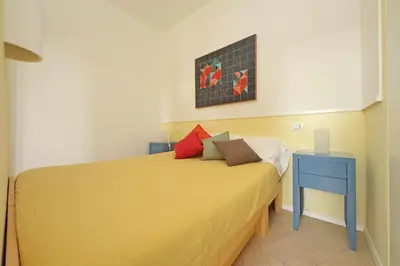 a bedroom with a yellow bed and a blue nightstand at YCH-Casa sul porto antico in Rome