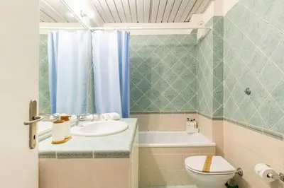 a bathroom with a sink and a toilet and a tub at Villa Borghese cozy apt in Rome