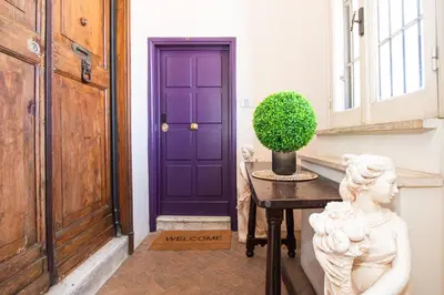 a purple door in a hallway with a statue next to a table at Alessio Luxury House Roma Pantheon-Piazza Navona in Rome