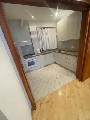 a kitchen with white cabinets and a tile floor at Carpegna Vatican House in Rome