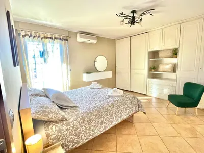 a bedroom with a bed and a green chair at RomaCentum Apartment Aurelio in Rome