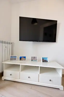 a white entertainment center with a flat screen tv on a wall at Ion Apartment in Rome