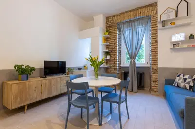a living room with a table and chairs and a blue couch at Brevi Roma Design Apartment in Rome