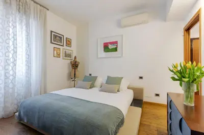 a bedroom with a large bed and a vase of flowers at Elegant Escape near the Vatican in Rome