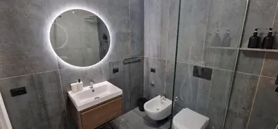 a bathroom with a sink and a mirror and a toilet at Nox Romana - Vatican - Luxury Flat with Terrace in Rome
