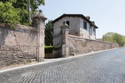 a stone wall with a gate on the side of a street at Loft Appia Antica Donna Eugenia in Rome