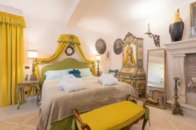 a bedroom with a large bed and a yellow bench at Loft Appia Antica Donna Eugenia in Rome